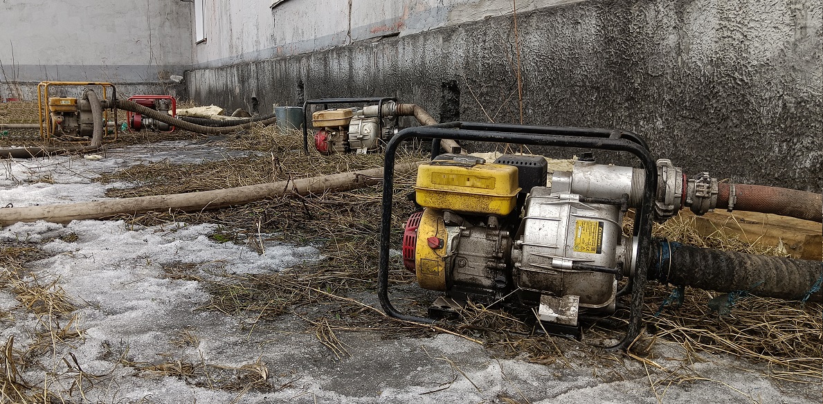 Откачка мотопомпами талой воды из подвала дома в Димитровграде
